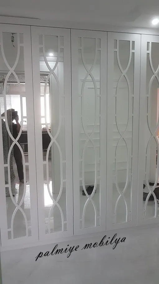 Beyaz lake portmantonun dalga motifli çıtalarla bölünmüş ayna kapaklarına önden bakış