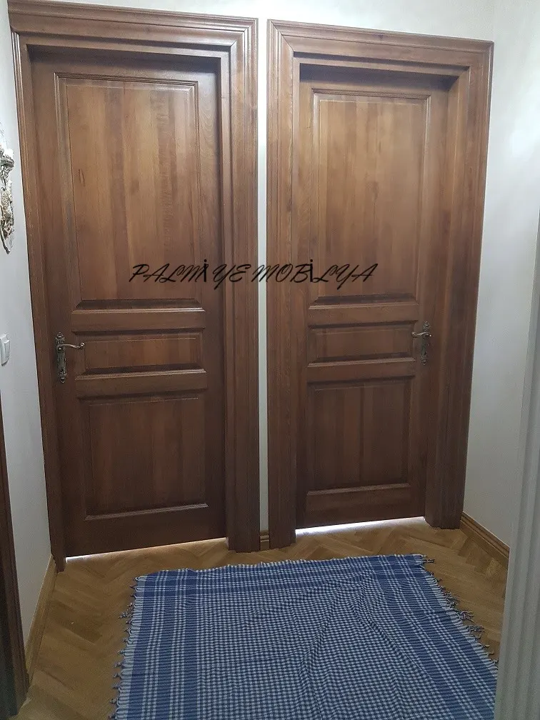 Balıksırtı parke koridorda yan yana iki bal tonlu panelli ahşap oda kapısı