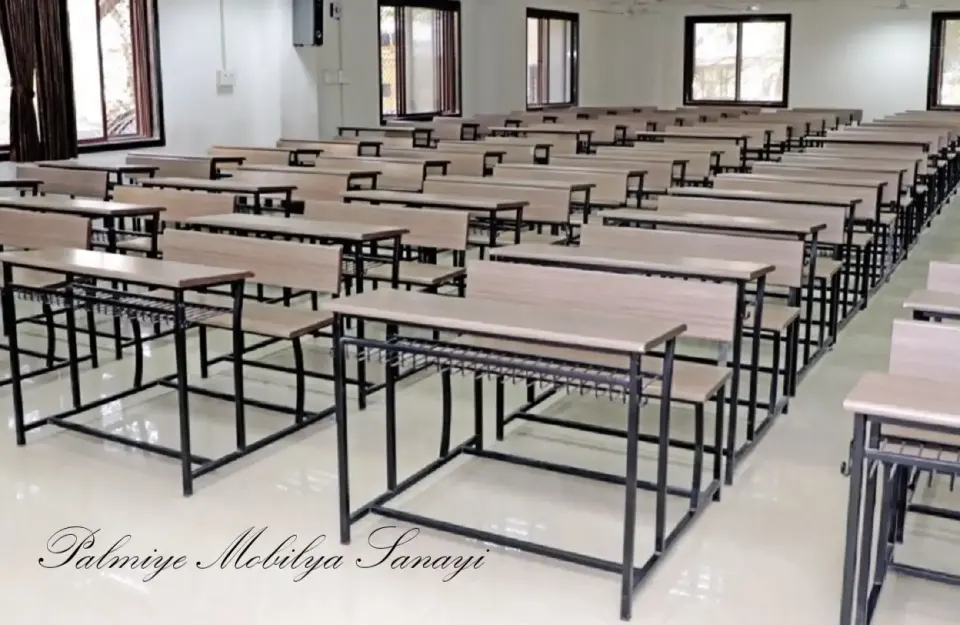 Geniş derslikte tel raflı metal iskeletli ahşap okul sıralarının uzun dizisi
