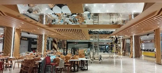 Ahşap çıtalı kolonların çevrelediği yemek alanında iskele ve aynalı tavan panelleri
