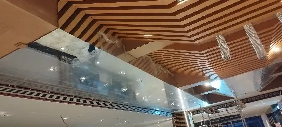 Ahşap çıtalı tavan ile cam panel birleşiminde koruma naylonu henüz sökülmemiş köşe