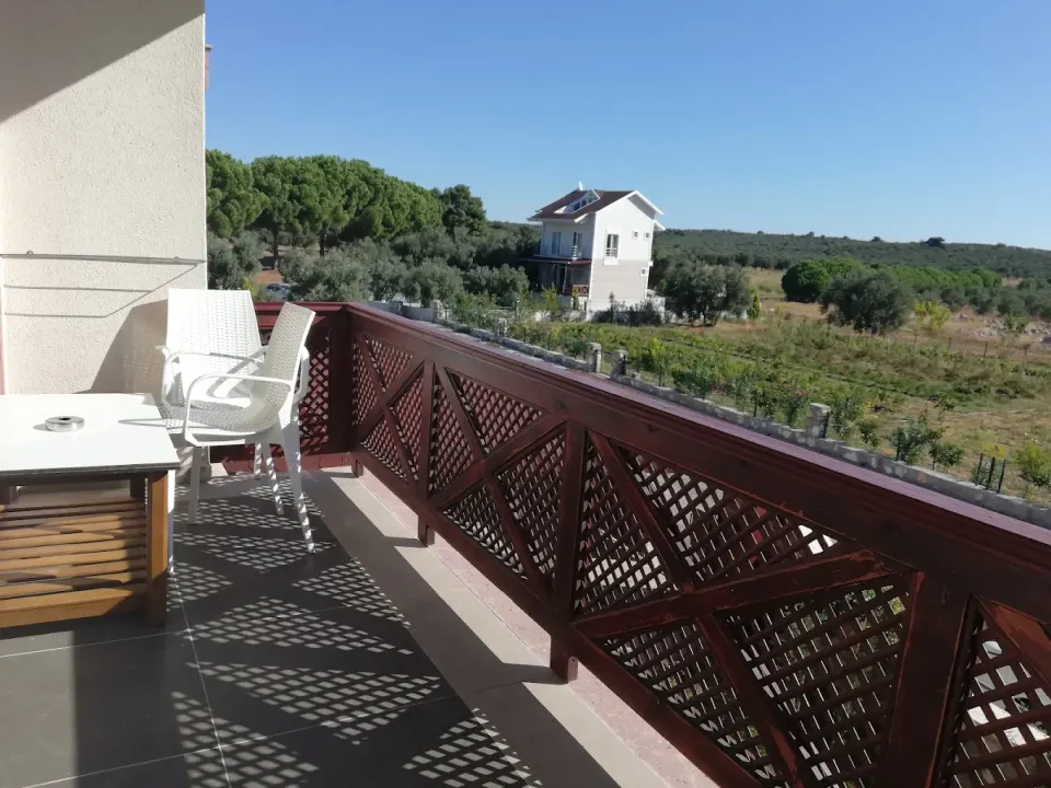 Otel Odası Balkonu – Ahşap Kafes Korkuluk, Hasır Sandalye