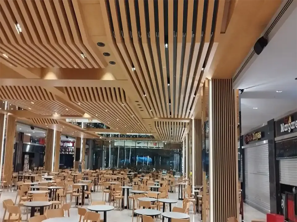 Otel yatak odası mobilyası yazısında yer alan ahşap çıtalı tavanlı geniş restoran salonu