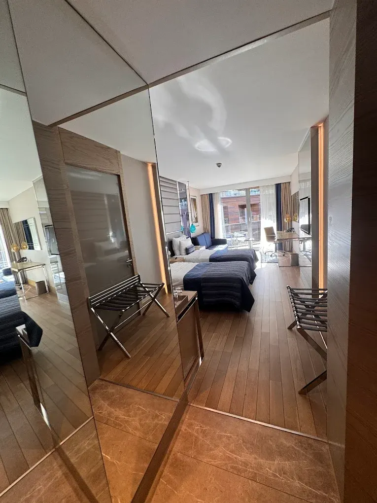 Otel Odası Girişi – Aynalı Duvar Paneli ve Bavul Sehpaları