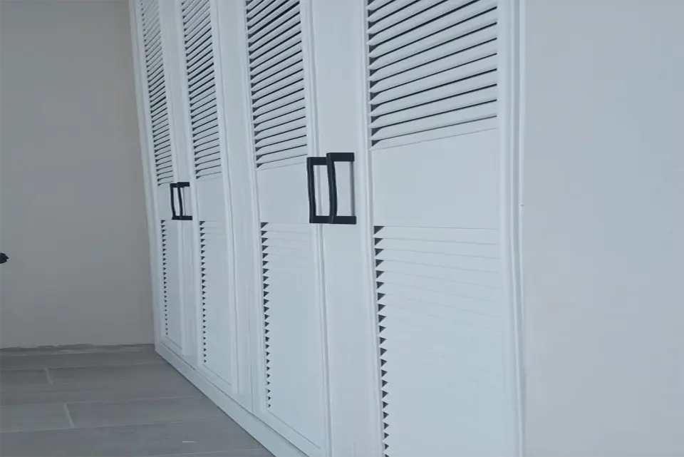 Gri seramik zeminli boş odada duvar boyu beyaz panjur dolap