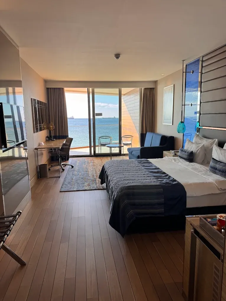 Deniz Manzaralı Otel Odası – Balkon Kapısı, Lacivert Kanepe